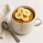 Banana pancakes mug served with toppings on cozy table