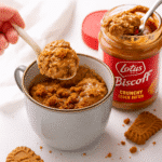 Biscoff mug cake scooped from a ceramic mug with cookie butter drizzle