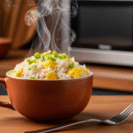 Completed egg fried rice in mug garnished with green onions and ready to serve