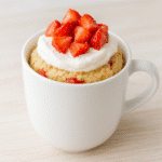 Strawberry Shortcake Mix-In Mug Cake with whipped cream and fresh strawberries