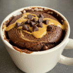 Peanut butter chocolate mug cake served in ceramic mug with steam rising