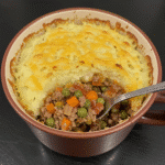 Shepherd's pie in a mug with golden potato topping and melted cheese