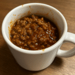 Sloppy Joe in a Mug recipe with ground beef and tangy sauce in white ceramic mug on wooden surface